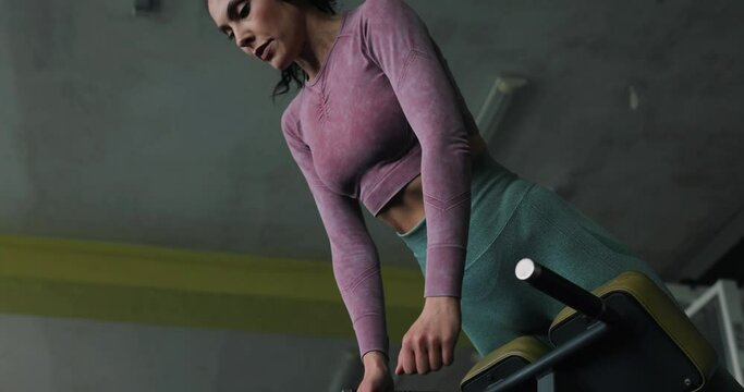 A woman doing hyperextension exercise at the gym