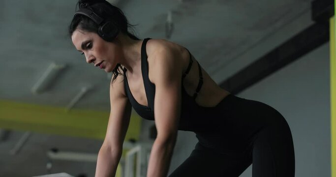 Woman lifting dumbbell at the gym for latissimus dorsi muscles