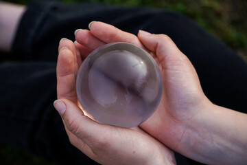 Crystal Sphere. Crystal Sphere, used for meditation, clairvoyance, health, luck and abundance! Hands covering the crystal sphere. Day photo. Crystal sphere in various angles.Various backgrounds. 