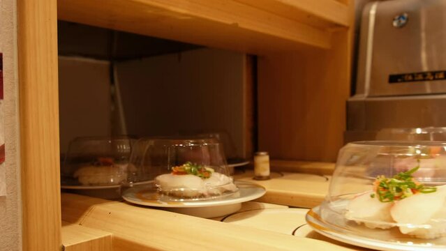 Sushi dishes riding on a conveyor belt at a Japanese restaurant.