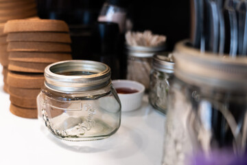 Glass bottles and various containers are placed on the table inside the restaurant