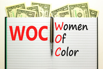 WOC women of color symbol. Concept words WOC women of color on beautiful white note. Dollar bills....