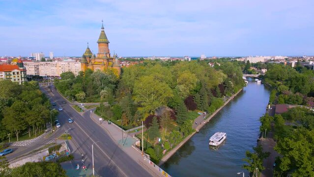 Aerial view of the beautiful city of Timisoara, Romania. Footage was shot from a drone from above the Bega river, with the Mitropolitan Cathedral and the city center in the view.