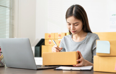 Startup small business, Young Asian women working freelance and packing box delivery products to...