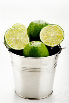 Close-up of a metal bucket filled with fresh limes