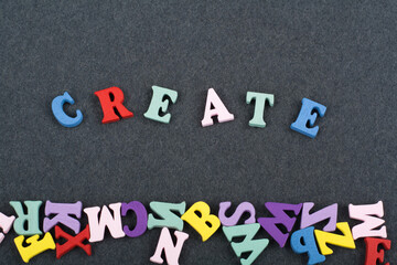 CREATE word on black board background composed from colorful abc alphabet block wooden letters, copy space for ad text. Learning english concept.