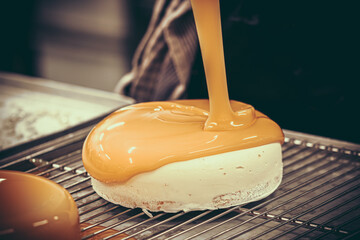Confectioner covers tart with a liquid orange glaze.