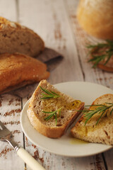 A loaf of rye bread with oil and rosemary in rustic style	