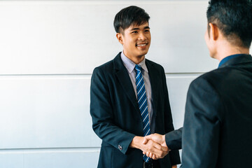 Business people agreement concept. Asian Businessman do handshake with another businessman in the...