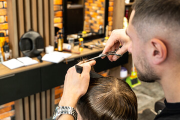 Lifestyle photo Barber shop blond boy customer. Hairdresser man work move hand comb tool scissors...