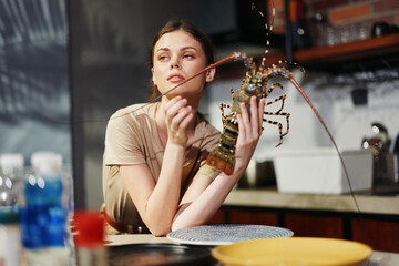 Woman holding a lobster at a kitchen table, preparing for a delicious seafood meal concept