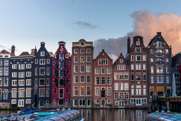 View of the Damrak canal dancing houses in Amsterdam at sunset