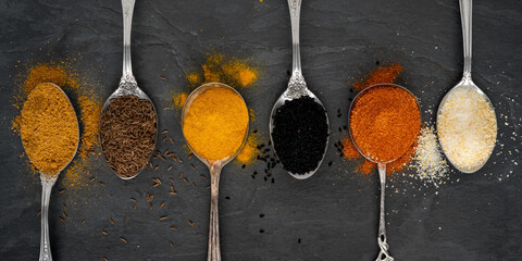 Various spices on tablespoons