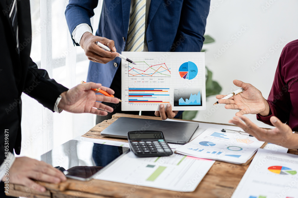 Poster Three people are standing around a table with a large graph on it