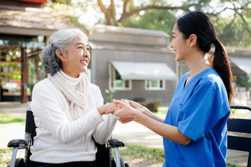 A woman in a blue uniform is holding a woman's hand in a park