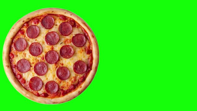 top view the salami pizza on the chromakey leaves from the left and starts spinning clockwise from the left with space for text