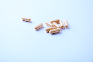 Lutein capsules. Dietary supplement on bright paper background. Soft focus. Close up. Copy space.