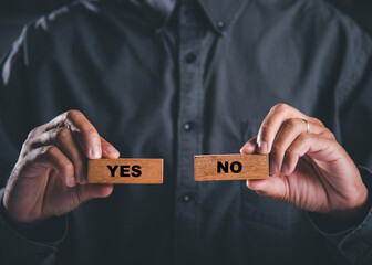 Businessman hands hold wooden blocks showing yes and no representing decision-making. Choice as a symbol of business success. Think With Yes Or No Choice.