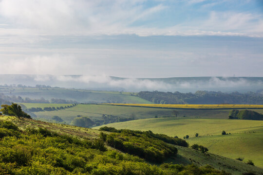 An idyllic view from Ditchling Beacon on a sunny morning in May, with mist in the Valley
