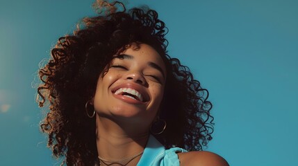 Joyful young woman smiling with a blue sky background radiating happiness