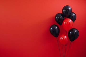 black balloon and red balloons on a uniform red background color
