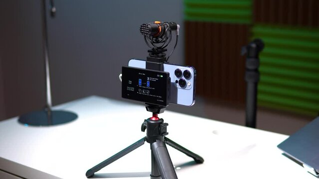 a young man film video of himself on the phone and displays the video on the monitor screen