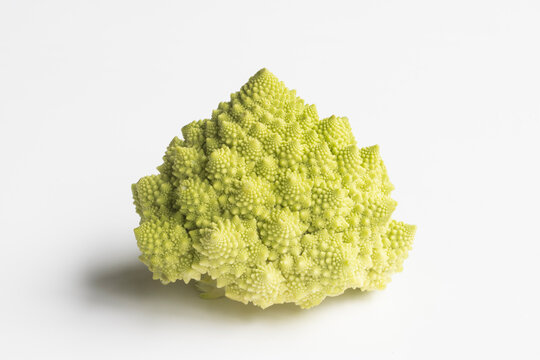 Closeup of a whole head of Romanesco cauliflower (also known as broccolo romanesco, romanesco broccoli, romanesque cauliflower) without leaves isolated on a white background.