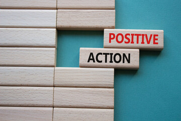 Positive action symbol. Concept words Positive action on wooden blocks. Beautiful grey green...