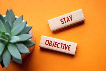 Stay Objective symbol. Wooden blocks with words Stay Objective. Beautiful orange background with...