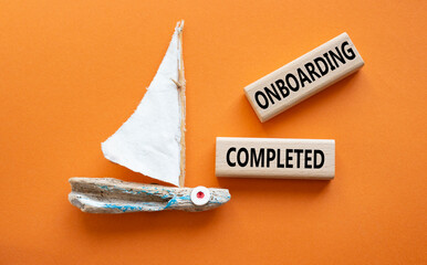Onboarding Completed symbol. Concept word Onboarding Completed on wooden blocks. Beautiful orange...