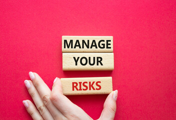 Manage your Risks symbol. Concept words Manage your Risks on wooden blocks. Businessman hand....