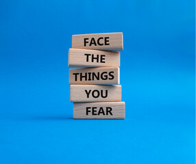 Face the things you fear symbol. Wooden blocks with words Face the things you fear. Beautiful blue...