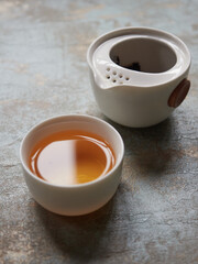 Small porcelain bowl with gold colored tea, individual teapot. Concept of minimalism and relaxation...