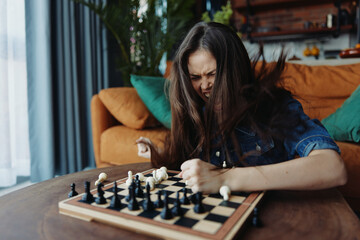 Woman enjoying a game of chess on a wooden board in a cozy living room setting