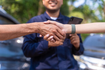 Happy asian insurance agent smiling to camera with two drivers can agree and shaking hands together after traffic accident. Parked on side way Call Emergency assistance or insurance claim service.