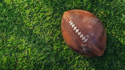 An old leather football sits on the grass.