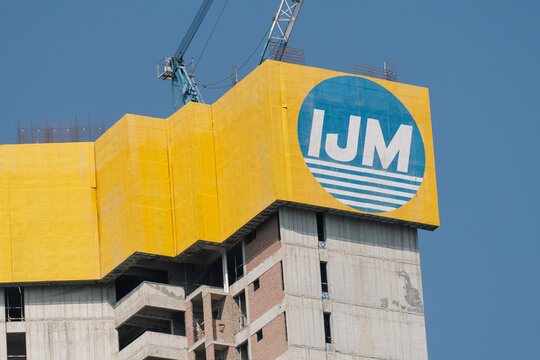 PENANG, MALAYSIA - APRIL 05, 2024: IJM logo displayed on the unfinished tower with a construction crane atop.