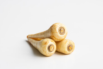 Three fresh parsnips isolated on a white background. Parsnip (Pastinaca sativa) is a root vegetable closely related to carrot and parsley, all belonging to the flowering plant family Apiaceae.