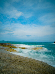 Aerial panorama of Thailand's verdant with blue and aquamarine the sea, and clouds shining by sunlight in the background.