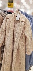 A beige woolen coat is in a supermarket