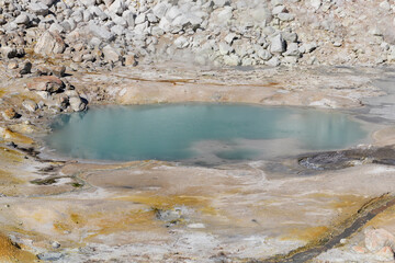 shiny blue little pond of hot smoking water at the Bumpass hell in lassen volcanic national park, california