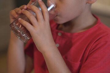 Close-up of a child drinking water, emphasizing the clarity of the glass and the refreshing moment....
