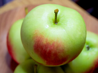 Fresh Green Apples. Crisp apples with a red blush on a wooden table.