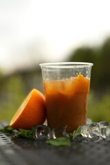 Non-alcoholic citrus cocktail in a plastic glass