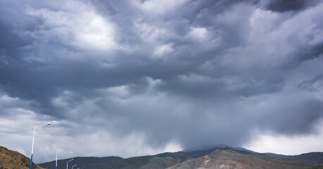 Cloudy rainy weather with clouds in the mountains, heavy rain and water pouring from the sky, rainy...