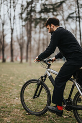 A professional businessman enjoys a relaxing bike ride in a city park, demonstrating work-life balance.