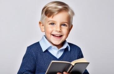 Happy smiling boy - preschooler or elementary school student with a book in his hands. Back to school. On a white background
