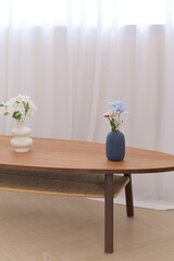 flower vase on the table beside white curtain in living room