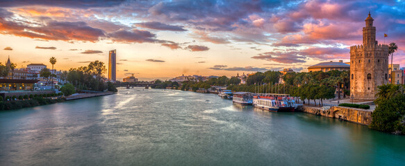 Fototapeta premium Panoramic view of the Guadalquivir River at dusk from San Telmo Bridge, Seville, Spain