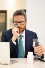 Man taking a medicine pill from headache migraine. Exhausted man feeling unhealthy, upset about headache illness. Stressed middle-aged man having headache. Migraine and headache concept.